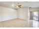 Spacious living room with tile flooring, ceiling fan, and sliding glass doors at 6319 W Hilton Ave, Phoenix, AZ 85043