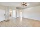 Open living room with tile flooring, ceiling fan and view of the entry and kitchen at 6319 W Hilton Ave, Phoenix, AZ 85043