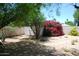 View of the backyard with a shed and colorful desert landscaping at 717 E State Ave, Phoenix, AZ 85020