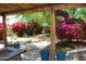 Covered backyard patio featuring bright bougainvillea and beautiful landscaping at 717 E State Ave, Phoenix, AZ 85020
