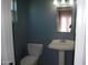 Half bath featuring a toilet, pedestal sink, and wall mirror with neutral colored walls at 717 E State Ave, Phoenix, AZ 85020