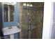 Stylish bathroom with a pedestal sink, tiled walk-in shower with a glass door and brushed nickel fixtures at 717 E State Ave, Phoenix, AZ 85020
