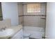 Tiled bathroom featuring a sink, toilet, and a bathtub with a tile surround and glass block window at 717 E State Ave, Phoenix, AZ 85020