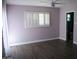 Comfortable bedroom with wood-look floors, neutral walls, plantation shutters and a view of the ensuite bath at 717 E State Ave, Phoenix, AZ 85020