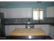 Kitchen featuring white cabinets, stainless steel appliances, dark countertops and a wood island at 717 E State Ave, Phoenix, AZ 85020