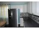 Kitchen with white cabinets, stainless steel fridge and hardware with a mosaic backsplash at 717 E State Ave, Phoenix, AZ 85020