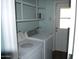 Functional laundry room featuring a washer, dryer, utility sink and overhead shelving at 717 E State Ave, Phoenix, AZ 85020