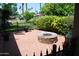 Relaxing outdoor patio with a cozy stone fire pit, brick pavers, and a wrought iron fence at 717 E State Ave, Phoenix, AZ 85020