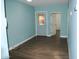 An empty room with wood floors and a back door that has a bright pink bush behind it at 717 E State Ave, Phoenix, AZ 85020