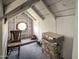 Attic features unique circular window, chair, and storage; a cozy space with potential at 7252 N Central Ave, Phoenix, AZ 85020