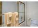 Bathroom with glass shower doors, white fixtures and a towel rack at 7252 N Central Ave, Phoenix, AZ 85020