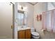 Cozy bathroom with floral wallpaper, complemented by a shower and vanity with wood cabinets at 7252 N Central Ave, Phoenix, AZ 85020