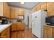 Functional kitchen with wooden cabinets, white appliances, and laminate floors, offering a simple design at 7252 N Central Ave, Phoenix, AZ 85020
