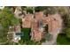Aerial view of an expansive property, including a large swimming pool, multiple terraces, and a meticulously manicured lawn at 7525 N Shadow Mountain Rd, Paradise Valley, AZ 85253