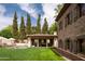 Stunning backyard featuring a pool, outdoor kitchen, lush lawn, and stone architecture at 7525 N Shadow Mountain Rd, Paradise Valley, AZ 85253