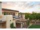 This stunning home features a balcony with outdoor seating, terra cotta roof, and views of mature trees and desert mountains at 7525 N Shadow Mountain Rd, Paradise Valley, AZ 85253