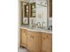 Close-up of a bathroom vanity with a marble countertop, stylish mirrors, and detailed wood cabinetry at 7525 N Shadow Mountain Rd, Paradise Valley, AZ 85253