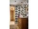 Bathroom featuring unique patterned wallpaper, wooden cabinet sink and a doorway to the tiled shower at 7525 N Shadow Mountain Rd, Paradise Valley, AZ 85253