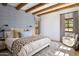 Stylish bedroom with exposed wood beams, patterned wallpaper, and a comfortable sitting area, perfect for relaxation at 7525 N Shadow Mountain Rd, Paradise Valley, AZ 85253