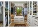Organized walk-in closet featuring custom shelving, drawers, glass doors, and a center window seat at 7525 N Shadow Mountain Rd, Paradise Valley, AZ 85253