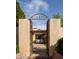 Charming courtyard featuring an intricate iron gate, lush plants, and glimpses of a cozy outdoor seating area at 7525 N Shadow Mountain Rd, Paradise Valley, AZ 85253
