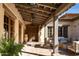 Inviting courtyard with wooden beams, a fire pit, a rustic entrance door, and comfortable outdoor seating at 7525 N Shadow Mountain Rd, Paradise Valley, AZ 85253