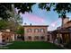 Stunning stone home with a beautifully landscaped backyard, a refreshing pool, and inviting outdoor seating at dusk at 7525 N Shadow Mountain Rd, Paradise Valley, AZ 85253