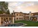 Expansive estate with a guest house, in-ground pool, lush lawn, stone exterior, and an outdoor kitchen with seating at 7525 N Shadow Mountain Rd, Paradise Valley, AZ 85253