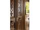 Close-up of the carved front door, featuring potted plants at 7525 N Shadow Mountain Rd, Paradise Valley, AZ 85253