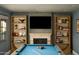 Game room features a pool table, fireplace, built-in shelving, and a large flat-screen television at 7525 N Shadow Mountain Rd, Paradise Valley, AZ 85253