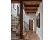 Hallway with wood staircase, beamed ceilings, wood door, and decorative art at 7525 N Shadow Mountain Rd, Paradise Valley, AZ 85253