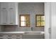 Bright kitchen featuring a farmhouse sink, subway tile backsplash, natural wood windows, and shaker cabinets at 7525 N Shadow Mountain Rd, Paradise Valley, AZ 85253