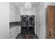 Well-organized laundry room with stacked washer and dryer units, ample white cabinetry, and modern lighting at 7525 N Shadow Mountain Rd, Paradise Valley, AZ 85253