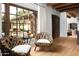Bright living area featuring wooden floors, a large window with outdoor views, and stylish woven chairs at 7525 N Shadow Mountain Rd, Paradise Valley, AZ 85253