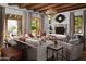Elegant living room with wood-beamed ceilings, a stone fireplace, and comfortable seating arrangements at 7525 N Shadow Mountain Rd, Paradise Valley, AZ 85253