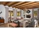 Bright living room with wood-beamed ceiling, elegant chandelier, and cozy seating area at 7525 N Shadow Mountain Rd, Paradise Valley, AZ 85253