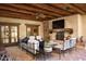 Covered outdoor living area featuring comfortable seating, fireplace, and wood beam ceiling at 7525 N Shadow Mountain Rd, Paradise Valley, AZ 85253