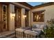 Cozy outdoor patio with comfortable seating, stone floors, and classic wall lanterns at 7525 N Shadow Mountain Rd, Paradise Valley, AZ 85253