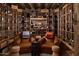 Spacious wine cellar featuring wooden racks filled with wine bottles, two leather chairs, and tiled floors at 7525 N Shadow Mountain Rd, Paradise Valley, AZ 85253