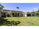 Wide exterior view of the home's back exterior, grassy yard and covered patios at 7834 E Mariposa Way, Mesa, AZ 85208