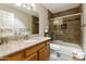 Bathroom with a sink and mirror over wood cabinets and a tub/shower with glass doors at 7834 E Mariposa Way, Mesa, AZ 85208