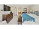 Bright bedroom with a large bed, a flat-screen TV, a wooden dresser, and an ensuite bathroom with double sinks at 7834 E Mariposa Way, Mesa, AZ 85208