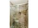 Shower with mosaic tile floor, a glass door, a tiled wall niche, and a shower head at 7834 E Mariposa Way, Mesa, AZ 85208