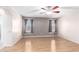 Spacious bedroom with light wood floors, ceiling fan, and two large windows at 7966 W Surrey Ave, Peoria, AZ 85381