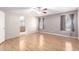 Bright bedroom with wood floors, ceiling fan, and doorway to en-suite bathroom at 7966 W Surrey Ave, Peoria, AZ 85381