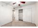 Carpeted bedroom with a ceiling fan, double closet, and adjoining door at 7966 W Surrey Ave, Peoria, AZ 85381