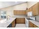 Well-lit kitchen with tile floors, light wood cabinets, and white appliances at 7966 W Surrey Ave, Peoria, AZ 85381