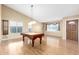 Spacious living room featuring hardwood floors and an elegant pool table with a chandelier at 7966 W Surrey Ave, Peoria, AZ 85381