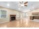 Spacious living room with brick fireplace, hardwood floors, ceiling fan, and adjoins kitchen at 7966 W Surrey Ave, Peoria, AZ 85381