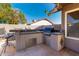 Outdoor kitchen with built in stainless steel BBQ, storage and serving area at 7966 W Surrey Ave, Peoria, AZ 85381